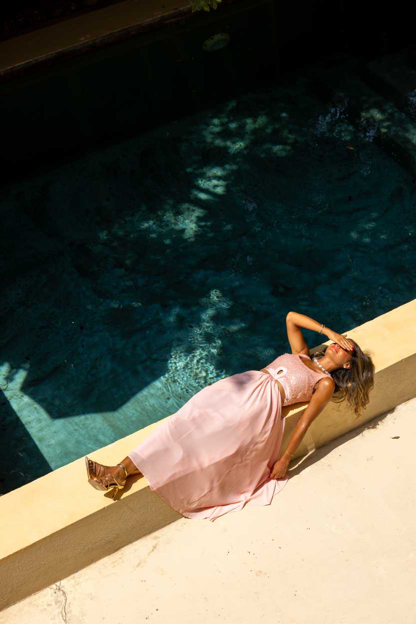 Woman in a pink dress lying by a pool Clep