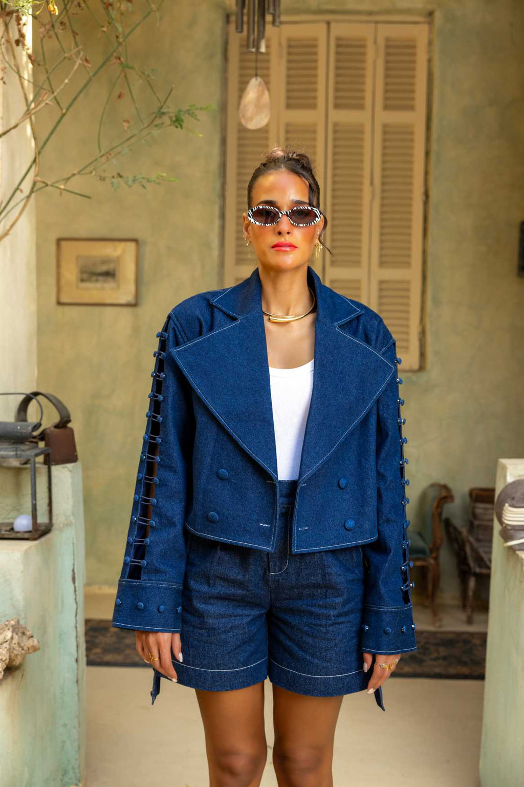 Woman wearing a blue outfit with sunglasses in an outdoor setting Clep