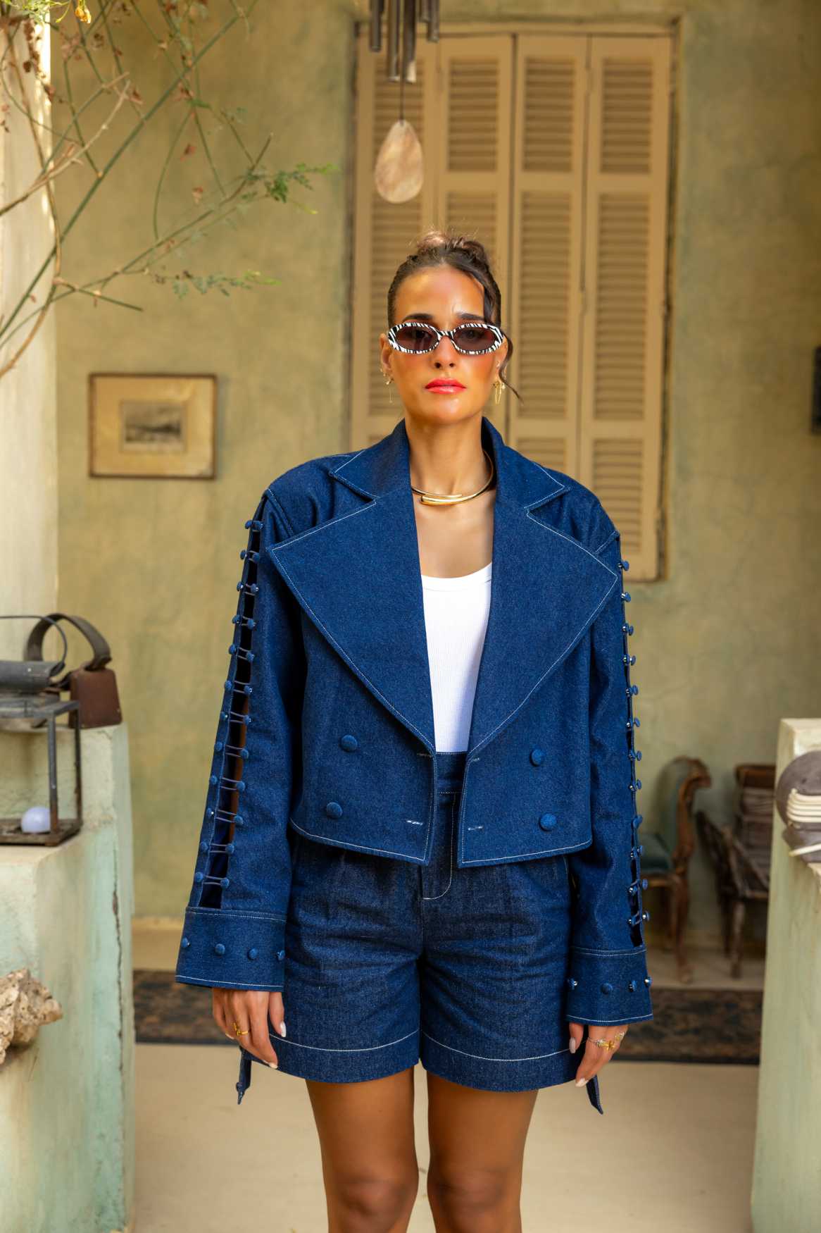 Woman wearing a blue outfit with sunglasses in an outdoor setting Clep