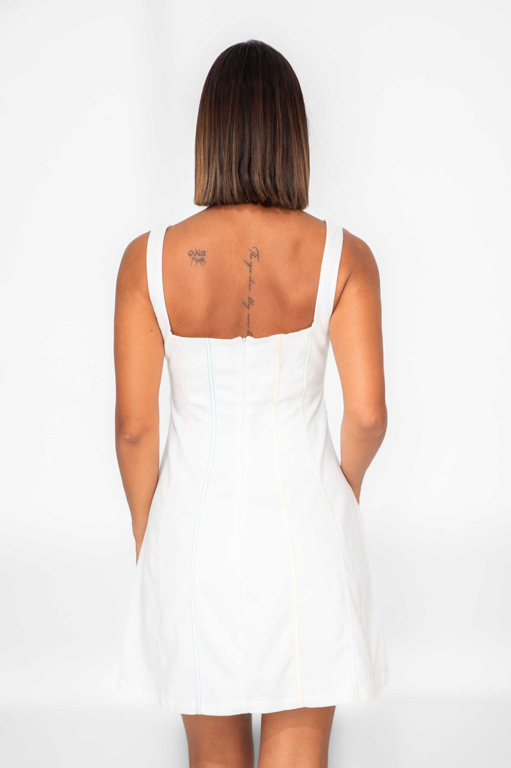 Person wearing a white dress with cut-out sides on a white background Clep