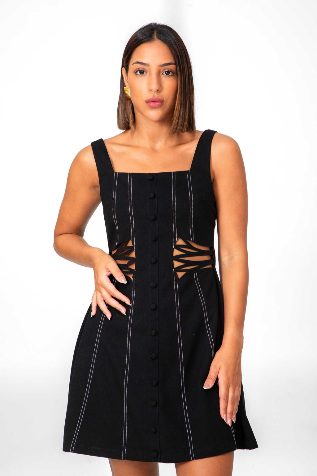 Woman wearing a black dress with cut-out design on a white background Clep