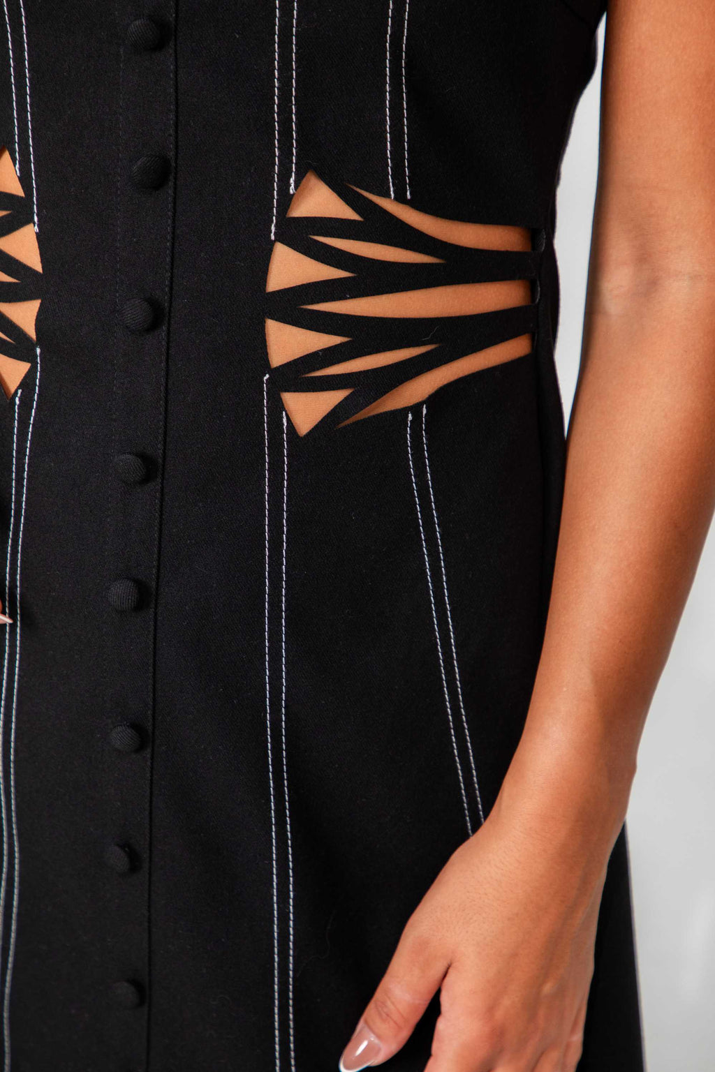 Black dress with cut-out design on a plain background Clep