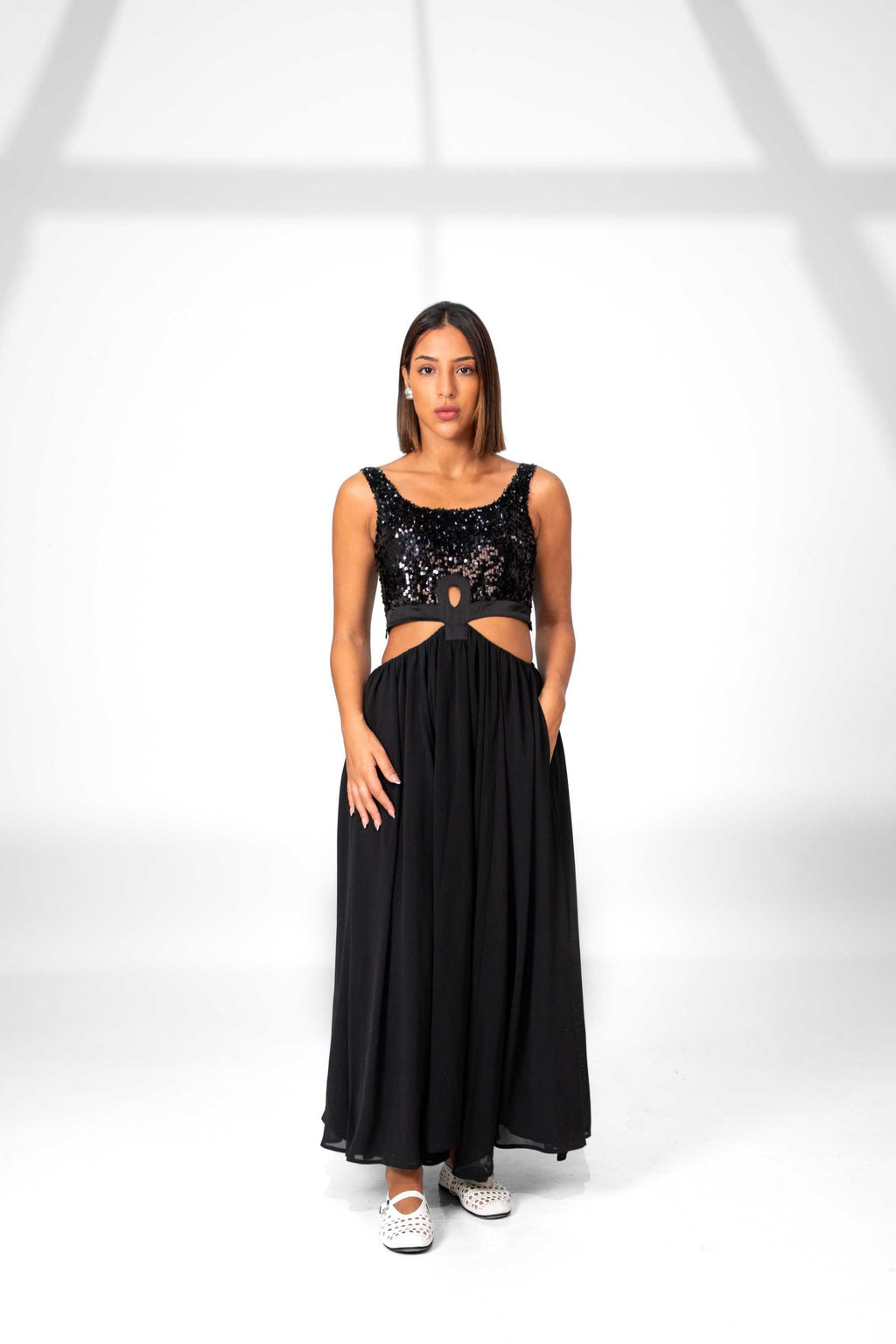 Woman wearing a black dress with cut-out design on a white background Clep
