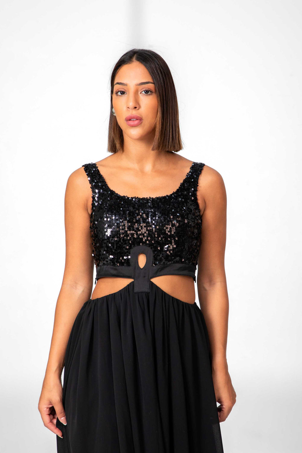 Woman wearing a black sequin top and black skirt on a white background Clep