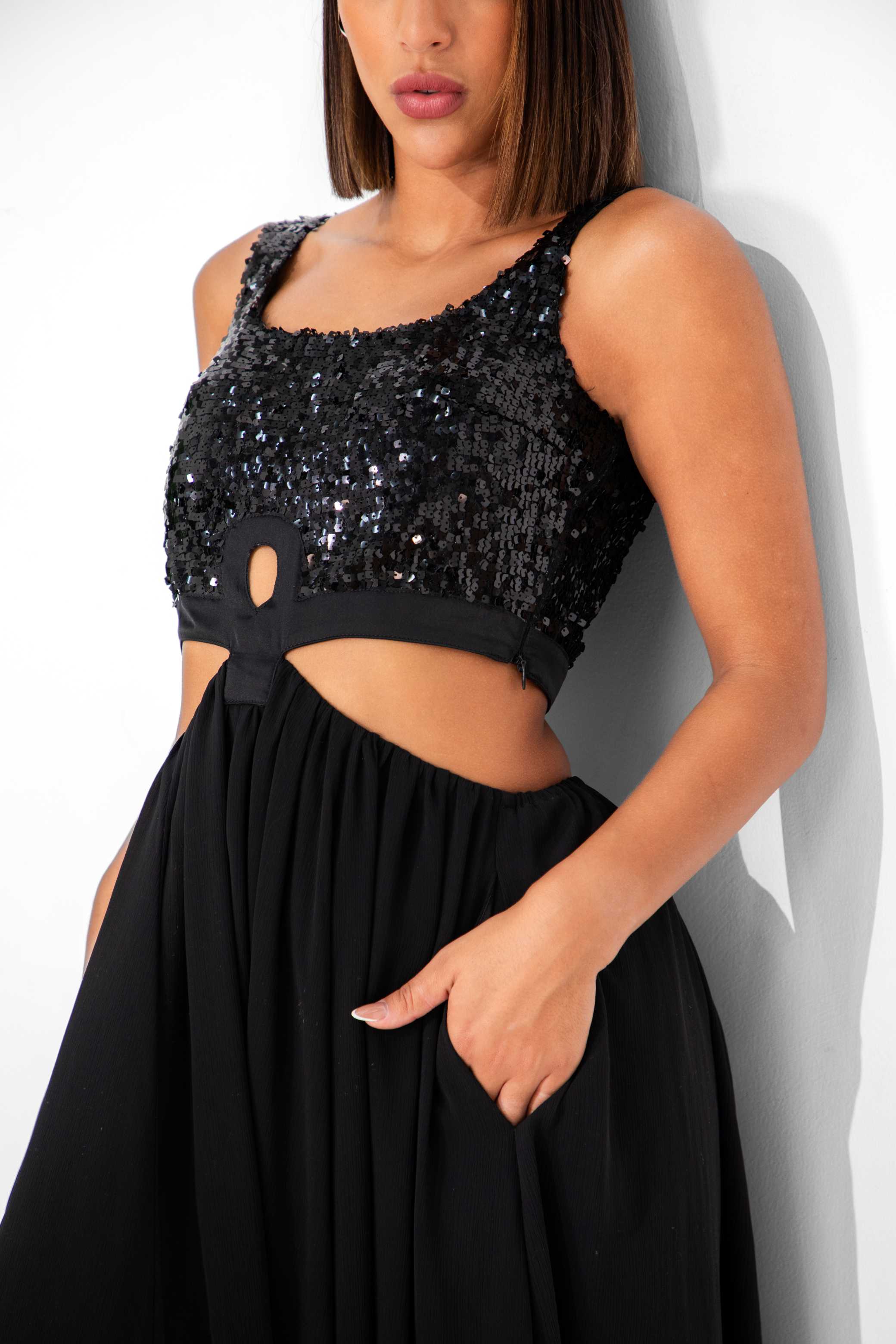 Black sequin top and black skirt worn by a person against a white background Clep