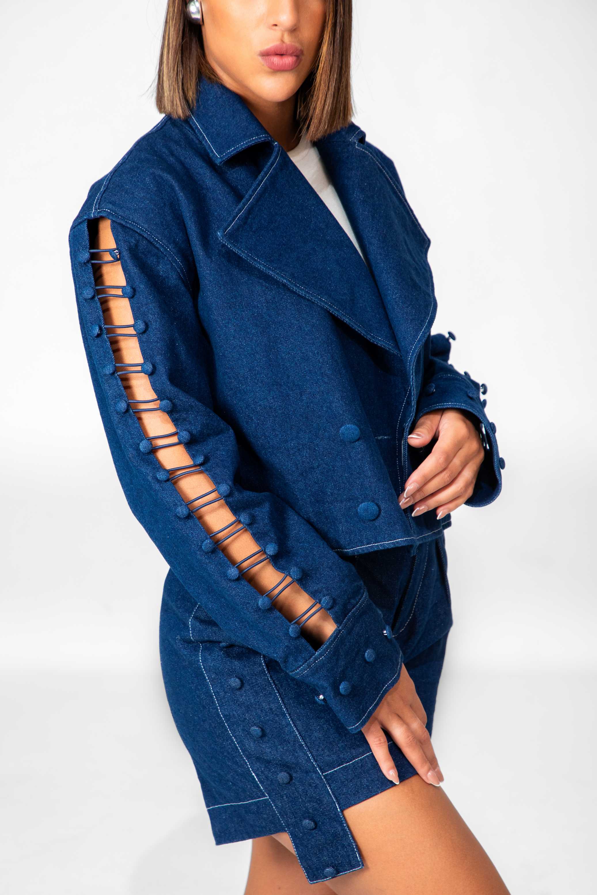 Woman wearing a blue coat with unique sleeve design on a white background Clep