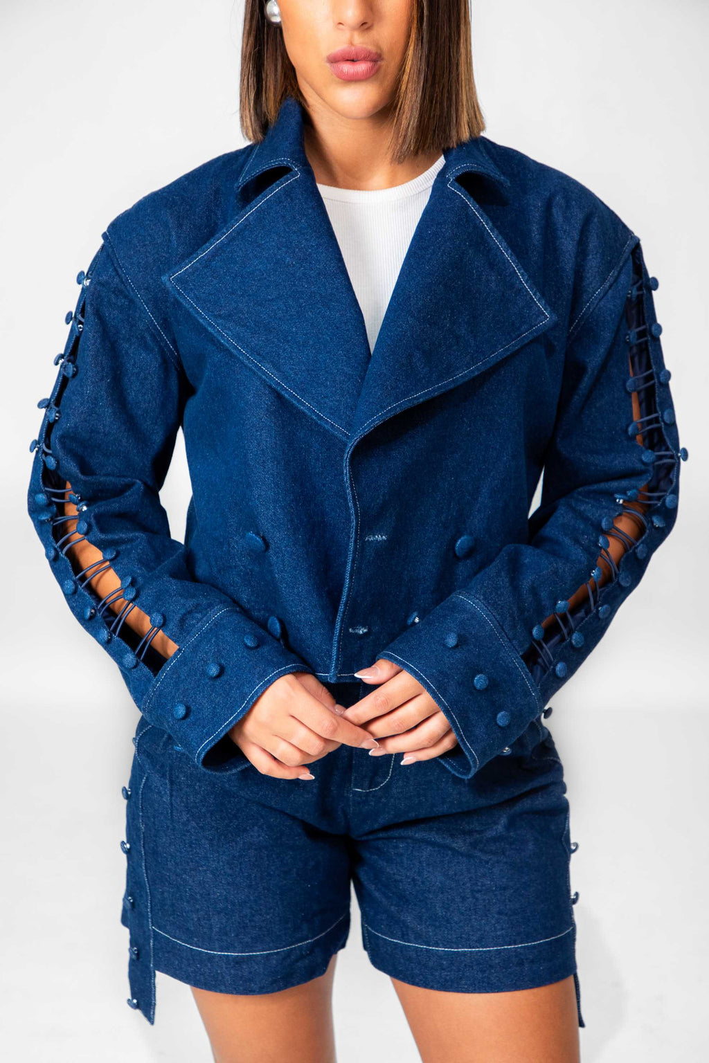 Blue jacket with unique sleeve designs worn by a person on a white background Clep