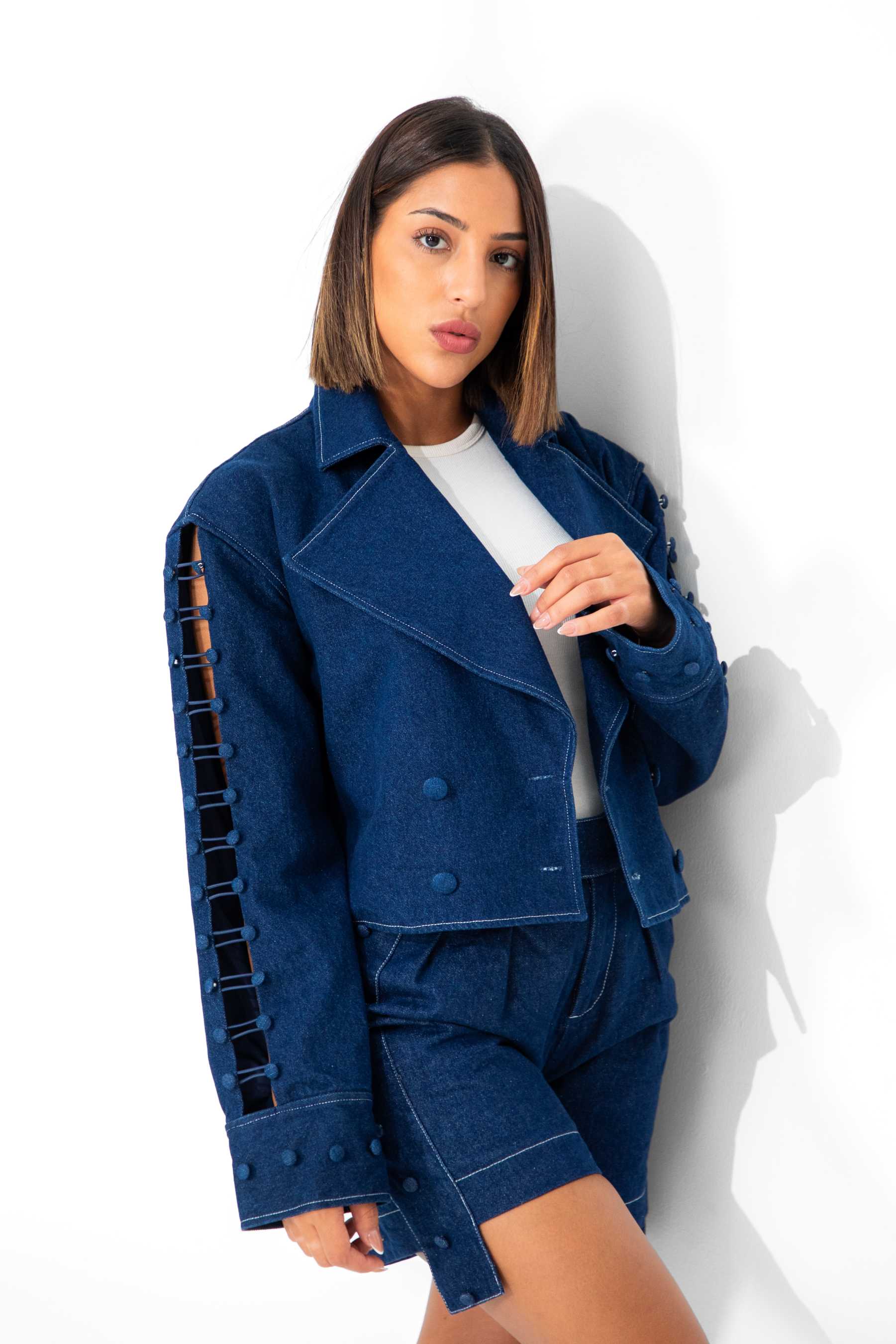 Woman wearing a blue denim jacket and shorts against a white background Clep