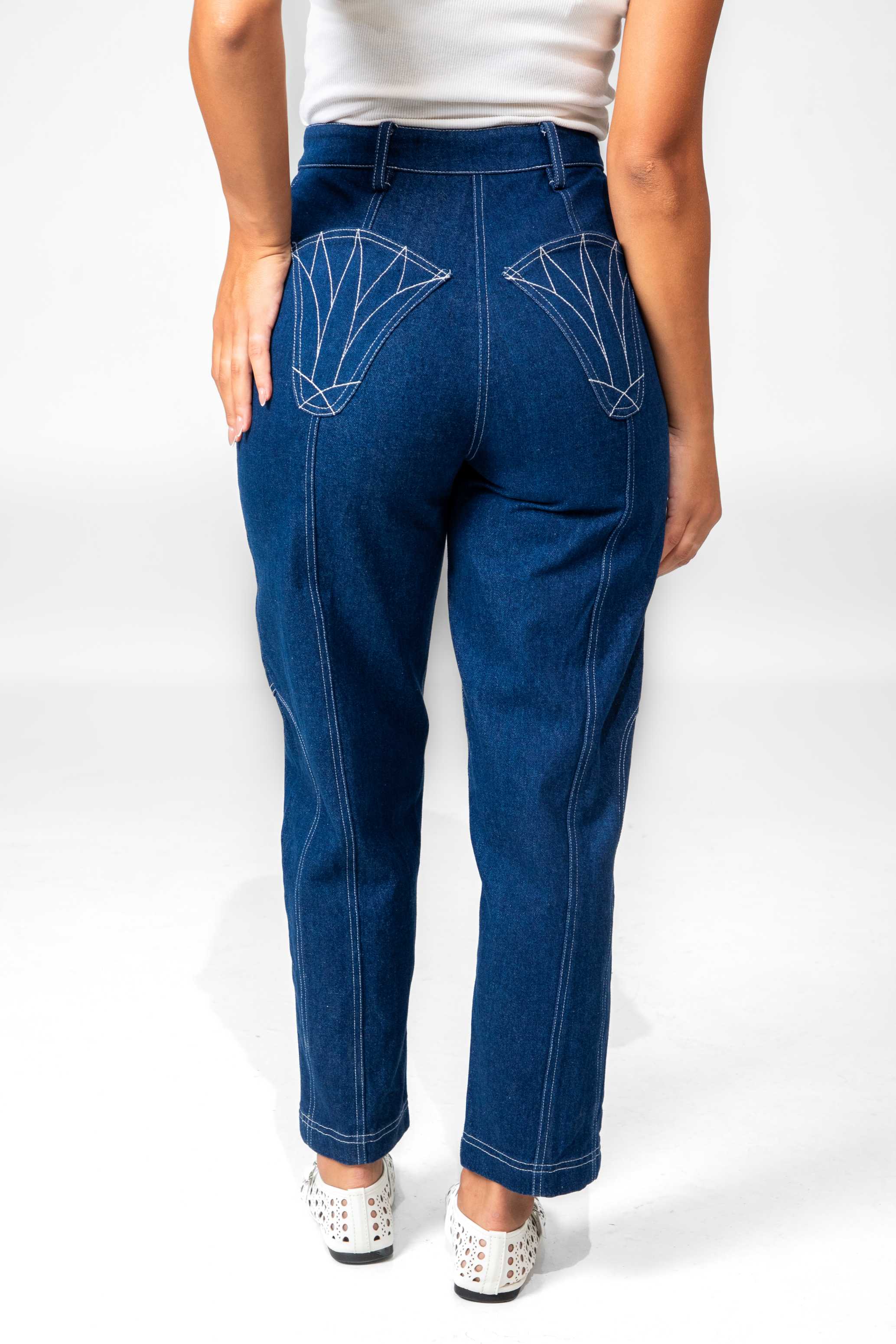 Person wearing blue jeans with white geometric designs on a white background Clep