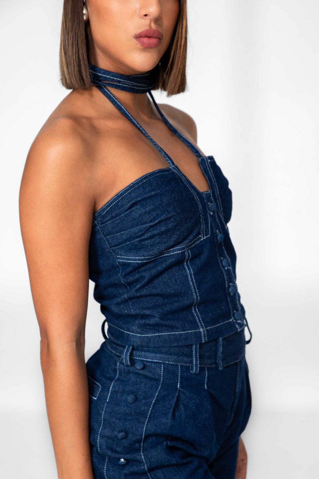 Woman wearing a blue denim outfit against a white background Clep