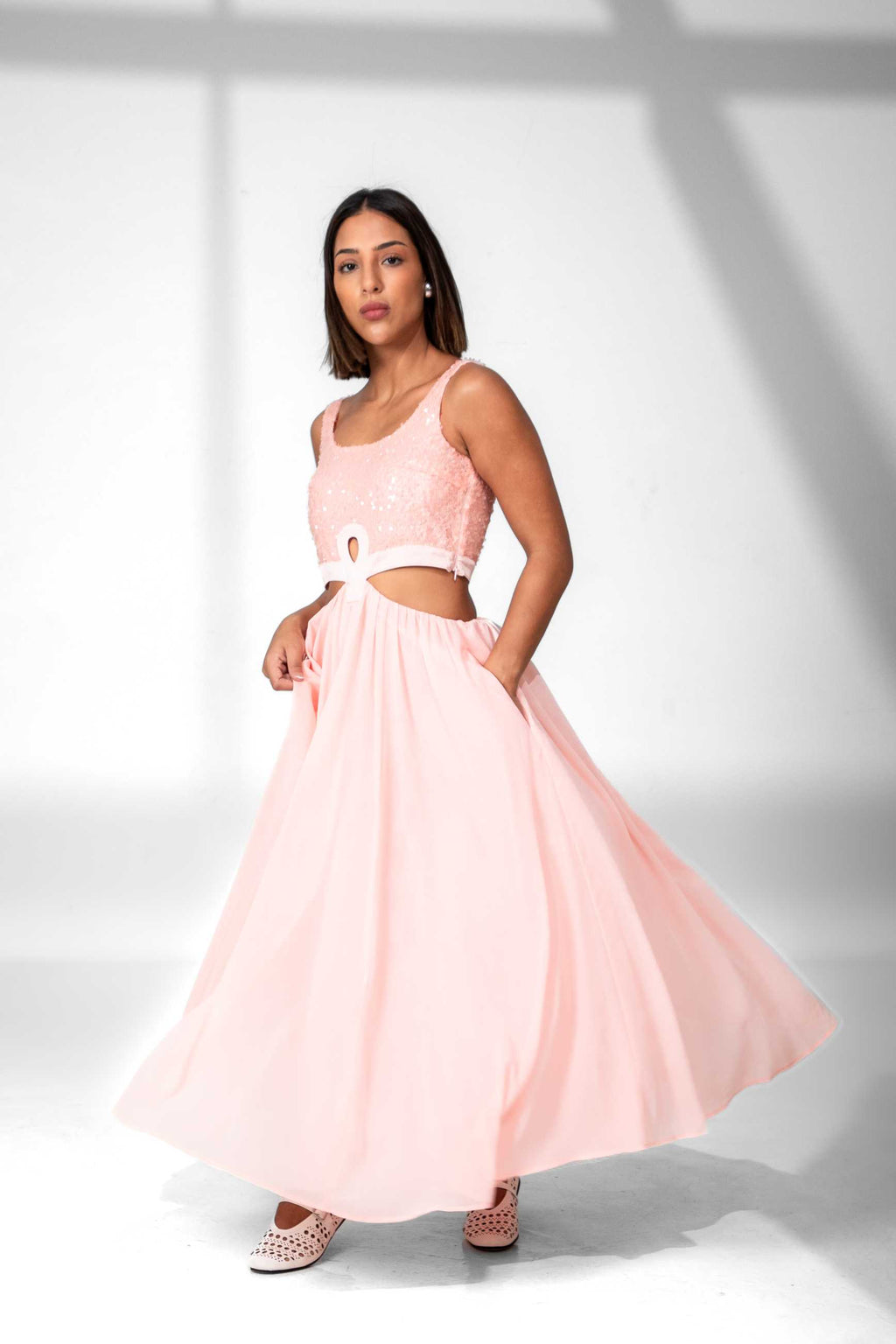 Woman wearing a pink dress with a white background Clep