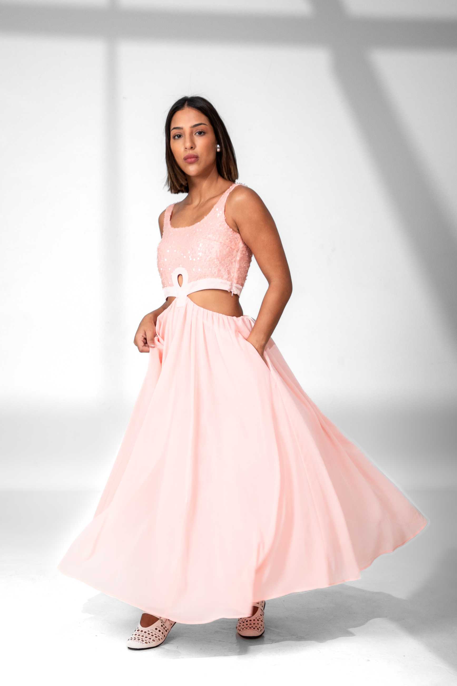 Woman wearing a pink dress with a white background Clep