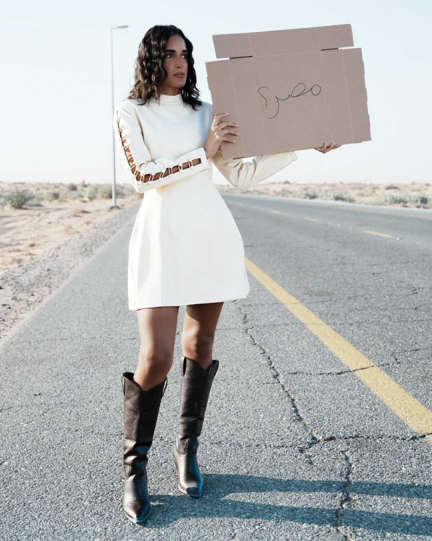 Person holding a cardboard box with 'egypt' written on it in a desert setting Clep